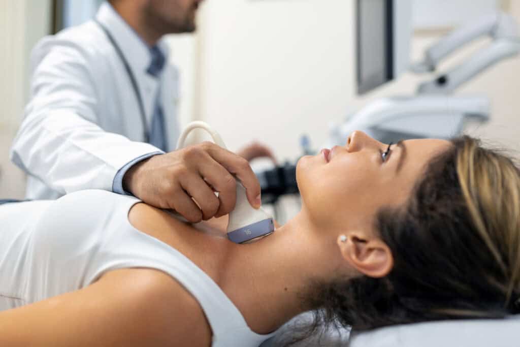 close up shot young woman getting her neck examined by doctor using ultrasound scanner modern clinic